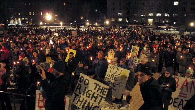 People participate in a candlelight vigil and rally Feb. 1 outside the Statehouse in Montpelierto oppose President Donald Trump's temporary suspension of immigration from seven Muslim-majority countries.