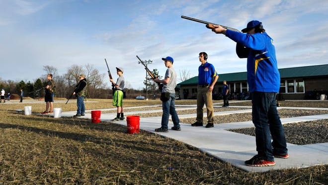 Members of the Kimball High School trap shooting team take turns shooting during practice as coach Rob Kuechle watches April 15 at the Kimball Rod & Gun Club.