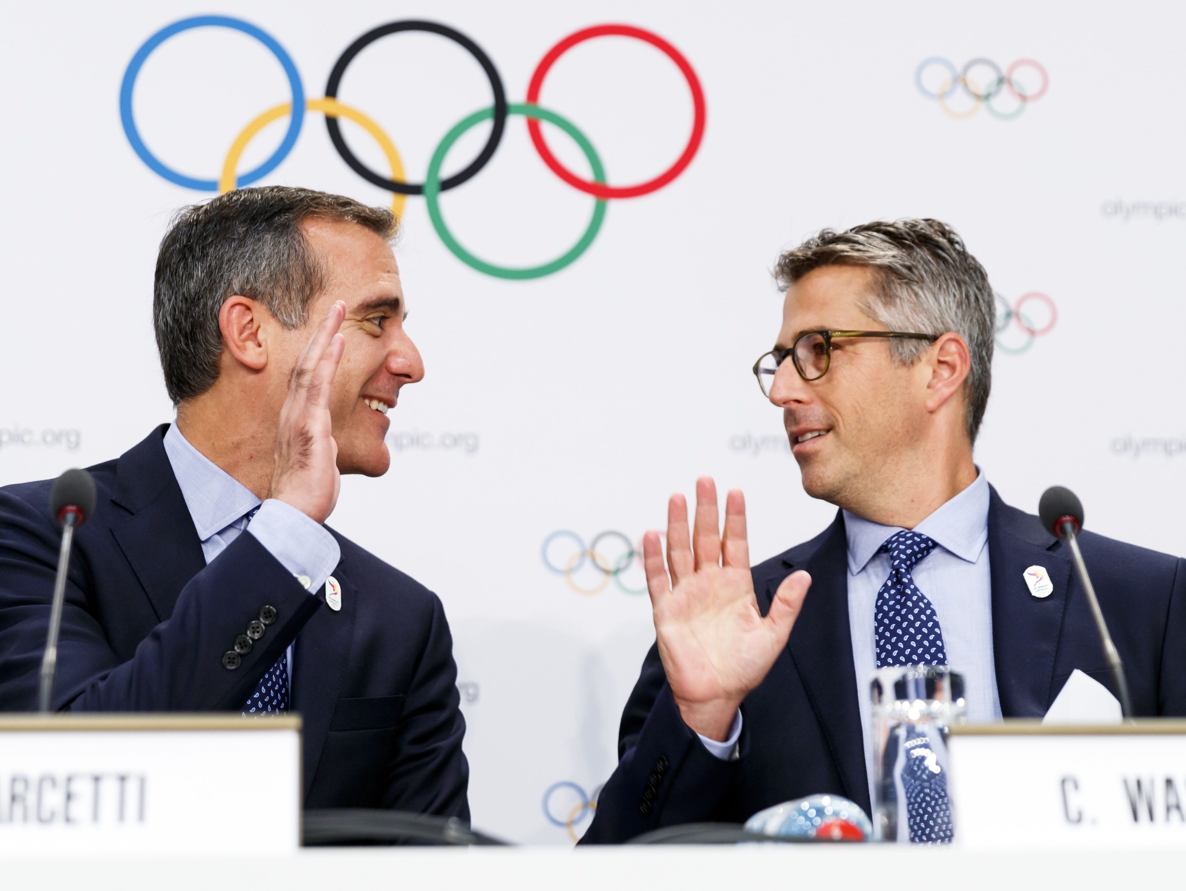 Eric Garcetti, mayor of Los Angeles, left, and Casey Wasserman, chairman of Los Angeles 2024, right, high five each other during a news conference after the presentation of Los Angeles 2024 Candidate City Briefing for International Olympic Committee 