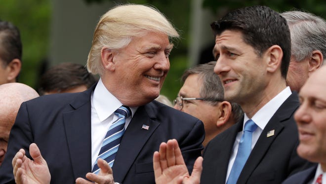 President Donald Trump talks with House Speaker Paul Ryan after the House approved a GOP-backed bill to replace Obamacare.