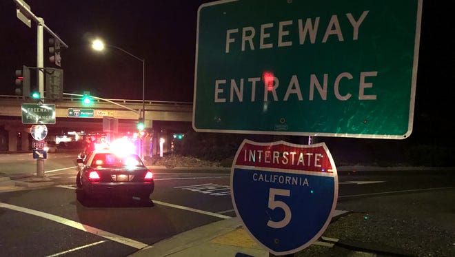 Two Redding patrol cars block the southbound on-ramp onto Interstate 5 on Wednesday night due to a pedestrian being struck and killed on the freeway.