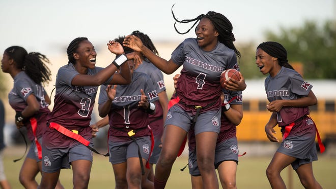 Fort Pierce Westwood's Tatyana Bourjolly (center) is congratulated by teammates after making the winning touchdown reception with under two minutes to play in the fourth quarter against Treasure Coast during the high school flag football game Thursday, March 8, 2018, at Treasure Coast High School in Port St. Lucie.