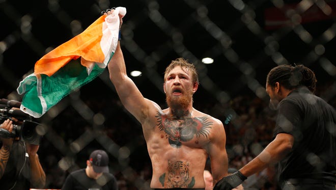 Conor McGregor celebrates after defeating Chad Mendes during their interim featherweight title mixed martial arts bout at UFC 189 on Saturday, July 11, 2015, in Las Vegas.