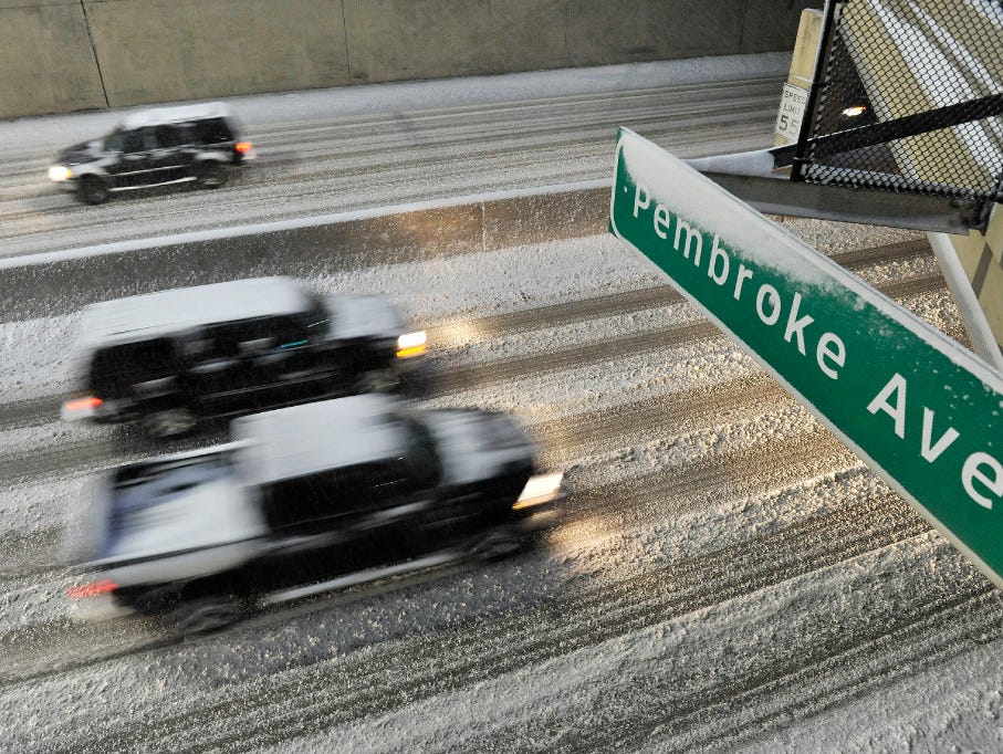 Traffic goes by on the snow-covered Lodge Freeway in Detroit, Sunday, Dec. 11, 2016. Much of Michigan's southern Lower Peninsula, from Lake Michigan to Lake Huron, is under a winter storm warning.
