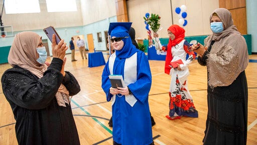 Melak Jashaami, center, is surrounded by family and friends dancing and clapping in a traditional Arabic celebration honoring Jashaami's graduation on Wednesday, Aug. 12, 2020 from Lewiston High School. The single person ceremonies happened at hour intervals through the day at Connors Elementary School in Lewiston to keep participants safer from the risk of COVID-19 transmission.