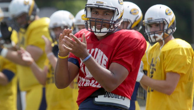Saline quarterback Josh Jackson warms up on the field before a scrimmage against Dearborn on Aug. 20.