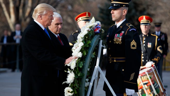 President-elect Donald Trump, accompanied by Vice President-elect Mike Pence, places a wreath at the Tomb of the Unknowns, Thursday, Jan. 19, 2017, at Arlington National Cemetery in Arlington, Va., ahead of Friday's presidential inauguration.