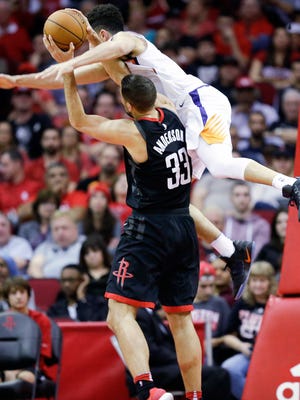 Phoenix Suns guard Devin Booker, top, fouls Houston Rockets forward Ryan Anderson during the second half of an NBA basketball game, Sunday, Jan. 28, 2018, in Houston. Houston won 113-102.