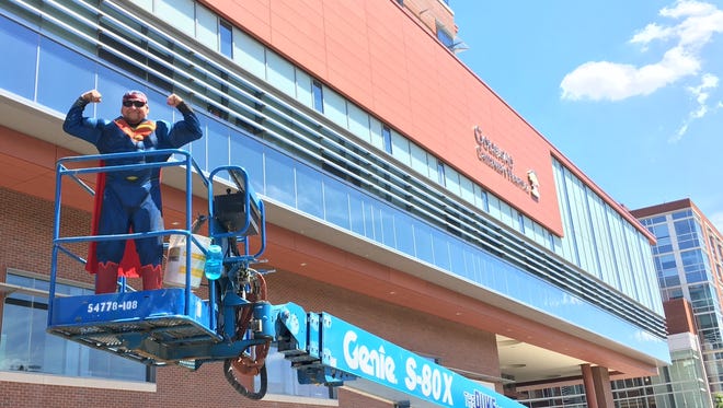 John Adams of Rochester Window Cleaning poses as Superman at Golisano Children's Hospital Thursday.