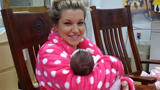 Kristin Balkovec uses a recently donated Eleonore Rocks chair to rock her week-old baby Lyla.