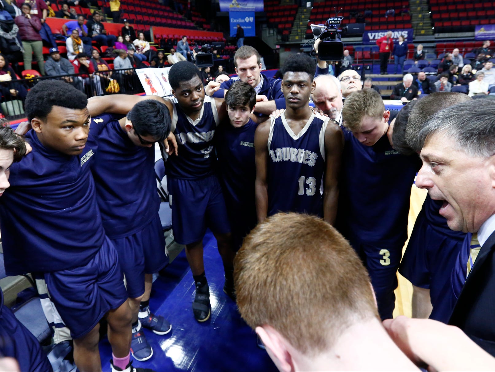 Our Lady of Lourdes head coach James Santoro, right, talks to his players after their 54-43 loss to Irondequoit in the NYSPHSAA boys Class A final at Floyd L. Maines Veterans Memorial Arena in Binghamton on Sunday, March 19, 2017.