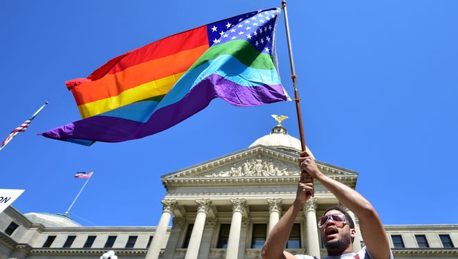 Meridian resident Nykolas Alford waves a rainbow-colored American flag on the Capitol steps March 29 during a Human Rights Campaign protest of House Bill 1523, which critics call discriminatory.