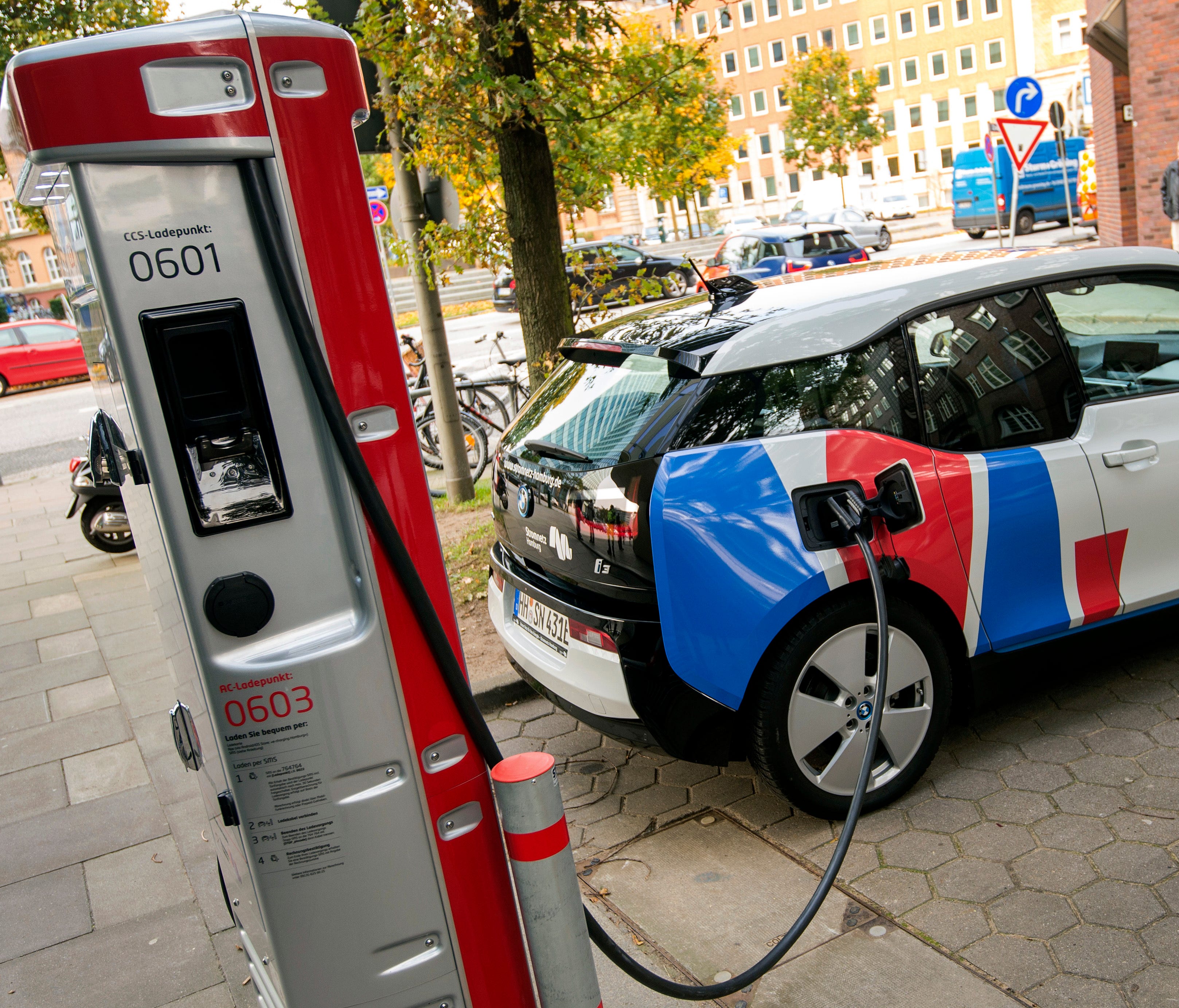 A car is connected to a charging station for electric vehicles in Hamburg, Germany. Major automakers say their joint European electric car recharging network will open its first stations this year in Germany, Austria and Norway in what the companies 