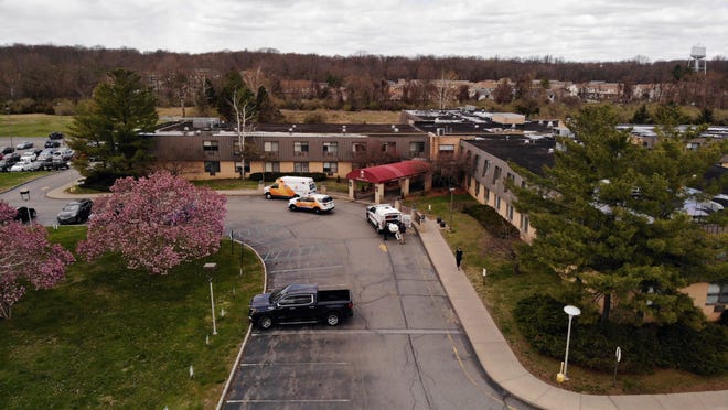 Ambulance crews are parked outside Andover Subacute and Rehabilitation Center in Andover, N.J., on Thursday April 16, 2020.   Police responding to an anonymous tip found more than a dozen bodies Sunday and Monday at the nursing home in northwestern New Jersey, according to news reports.  (AP Photo/Ted Shaffrey)