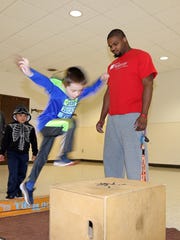 Owen Templeton, 6, of Ankeny jumps to the wooden box with instructor Paul Hubbard during the Parkour obstacle course training at the Lakeside Center in Hawkeye Park which is hosted by Ankeny Park and Recreation on Friday, April 6, 2018.