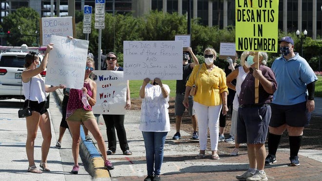 a small group of demonstrators gathers at Lake Eola Park to protest the Florida unemployment benefits system Wednesday, June 10, 2020, in Orlando, Fla. Many Florida unemployed workers are still trying to apply for and receive unemployment benefits since the start of the coronavirus pandemic.