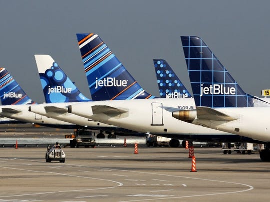 A line of JetBlue tails at airport gates