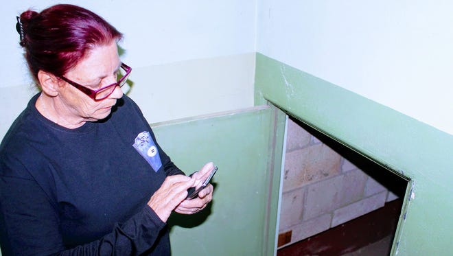 Hidden Haunts Paranormal Investigator Joanne Brandt turns on her cell phone flash light to inspect a small passage way on the third floor of the Everything Outwest vintage store, 819 N. New York Ave. Sunday, Feb. 19.