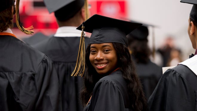 A Kenwood graduate smiles after finding her seat for a commencement ceremony.