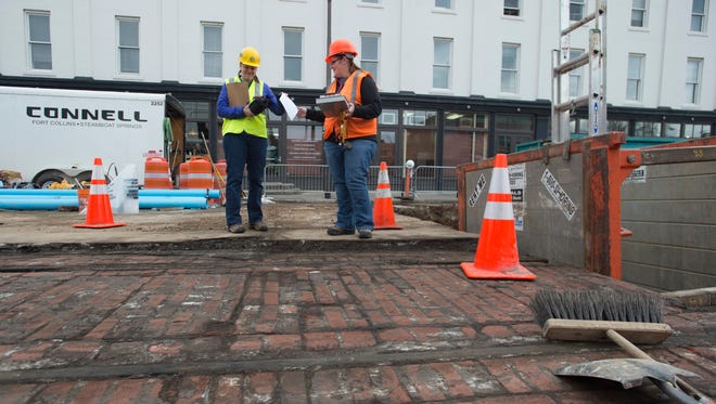 Eva Donkin and Kristin Gensmer of Centennial Archeology stand near a section of unearthed trolley track found during construction activities on Walnut Street in Old Town on Friday, January 19, 2018. The pair recorded data that may lead to details on the construction and use of the historic tracks. 
