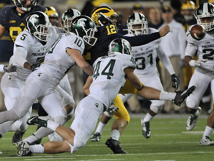 Michigan punter Blake O'Neill loses the ball on the