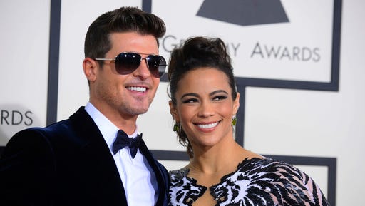 FILE - This Jan. 26, 2014 file photo shows Robin Thicke, left, and Paula Patton at the 56th annual Grammy Awards in Los Angeles.    In a Feb. 21, 2017, court filing, Patton's attorneys accused Thicke of evidence tampering by altering a court order in an attempt to get the actress arrested for kidnapping in an ongoing custody dispute between the former couple. The filing was released Thursday, Feb. 23, one day before a trial on allegations that Thicke abused her and their 6-year-old son is scheduled to begin in  Long Beach, Calif.