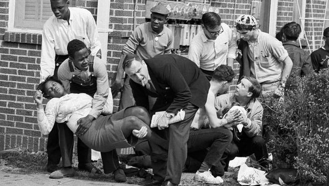 Amelia Boynton is carried and another injured man tended to after they were injured when state police broke up a demonstration march in Selma, Ala., on March 7, 1965.