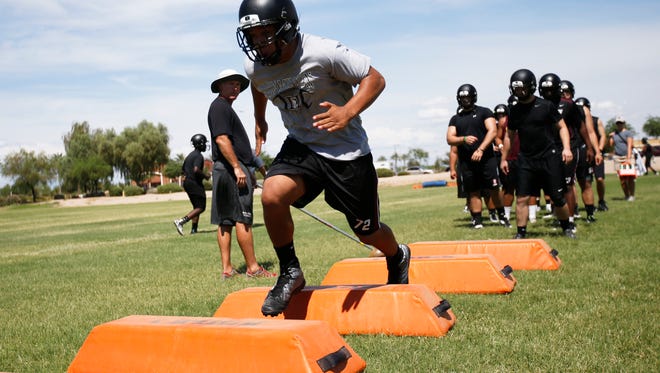 Hamilton High football players run through drills on the first day of practices July 28, 2014.