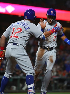 Chicago Cubs' Addison Russell, right, is congratulated by Kyle Schwarber after scoring on a wild pitch, and throwing error by San Francisco Giants catcher Nick Hundley during the seventh inning of a baseball game Tuesday, July 10, 2018, in San Francisco. (AP Photo/Ben Margot)