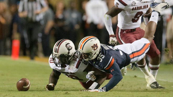 Auburn defensive back Jermaine Whitehead fights for the ball as South Carolina linebacker Skai Moore recovers the onside kick during Saturday's game.