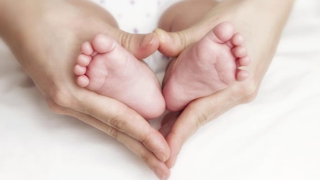 Newborn baby feet in the mother hands