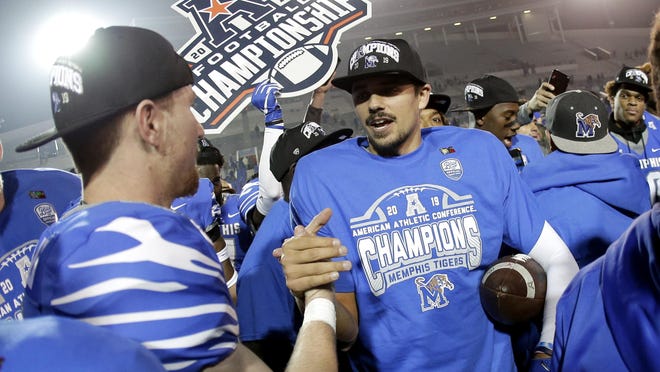 In this Dec. 7, 2019, file photo, Memphis quarterback Brady White, center, celebrates after his team defeated Cincinnati in an NCAA college football game for the American Athletic Conference championship, in Memphis, Tenn. The American Athletic Conference will require all its schools to test football players for COVID-19 at least 72 hours before competition.