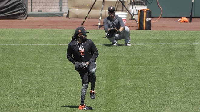 San Francisco Giants pitcher Johnny Cueto, foreground, throws to bullpen catcher Taira Uematsu during a baseball practice in San Francisco on July 5.