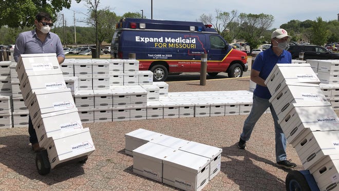 Campaign workers David Woodruff, left, and Jason White, right, in May deliver the initiative petitions that successfully put Amendment 2 on Tuesday's ballot. The Medicaid expansion measure passed and now the state must figure out how to implement it by July 1, 2021.