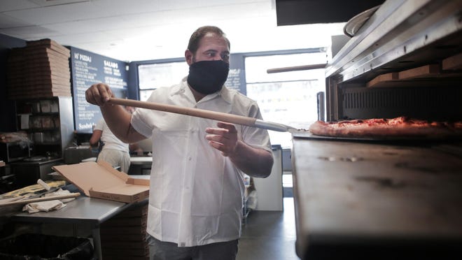 Donato Frattaroli Jr., co-owner of Boardwalk Pizza, puts a pizza in the oven.