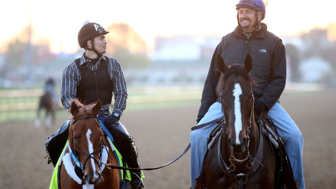 Trainer of Tapiture Steve Asmussen, right, is seen riding next to Tapiture after a workout at Churchill Downs. April 26, 2014