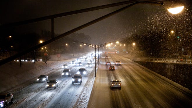 Traffic moves slow on I-490 as snow comes down and rush hour begins on Wednesday, December 10, 2014.