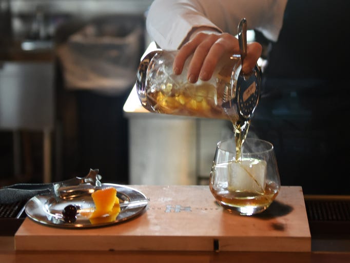 Trainer Brynn Ward of Tampa pours a smoked Old Fashioned
