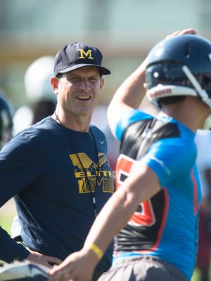 Michigan football coach Jim Harbaugh looks on during the Elite Summer Football Camp, Friday at Prattville High School in Prattville, Ala.