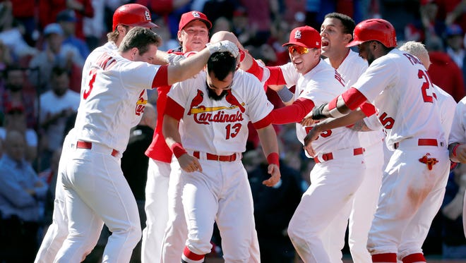 St. Louis Cardinals' Matt Carpenter (13) is congratulated by teammates after hitting a walk-off grand slam to defeat the Toronto Blue Jays 8-4 in 11 innings in the first baseball game of a doubleheader Thursday, April 27, 2017, in St. Louis.