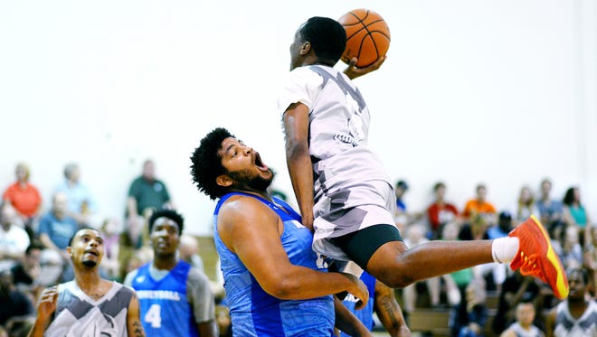 Colin Jones, left, tries to take a charge from Michigan State's Cassius Winston during their Moneyball Pro-Am game earlier this summer. Jones, who weighs 264 pounds and wears the jersey tight, is a fan favorite, because of his size and game.
