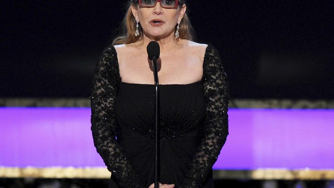 FILE - In this Sunday, Jan. 25, 2015 file photo, Carrie Fisher presents the life achievement award on stage at the 21st annual Screen Actors Guild Awards at the Shrine Auditorium in Los Angeles. Fisher has reportedly been transported to a hospital after suffering a severe medical emergency on a flight Friday, Dec. 23, 2016. (Photo by Vince Bucci/Invision/AP, File)