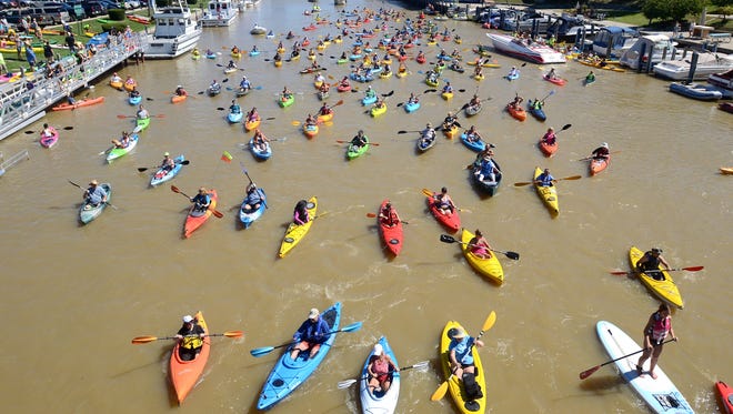 Kayakers head west on the Black River as they begin their journey Sunday in the annual Paddle and Pour event in Port Huron.