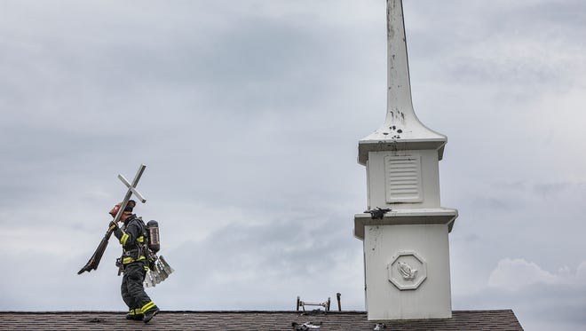Jordan Kartholl's photo for which he was honored during Saturday's HSPA banquet. A firefighter retrieves a cross from the top of Muncie First Freewill Baptist Church after lightning struck the church's steeple in late June.