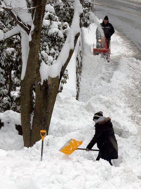 Residents clear snow after an overnight snowstorm dropped