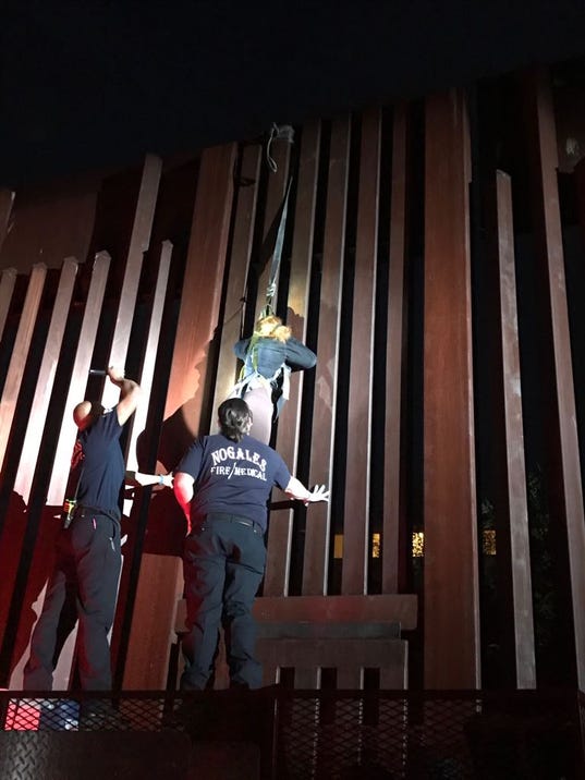Woman dangles from border fence
