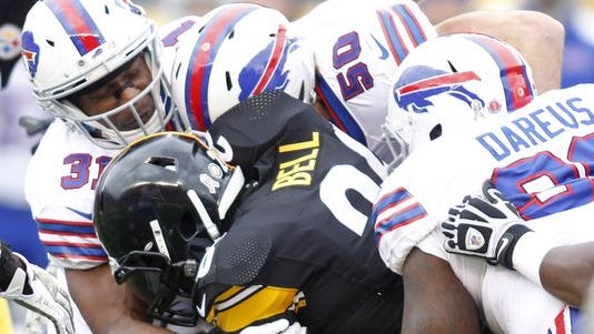 Pittsburgh Steelers running back Le'Veon Bell (26) rushes the ball and is tackled by Buffalo Bills free safety Jairus Byrd (31) and middle linebacker Kiko Alonso (50) and defensive tackle Marcell Dareus (99) during the first quarter against at Heinz Field.