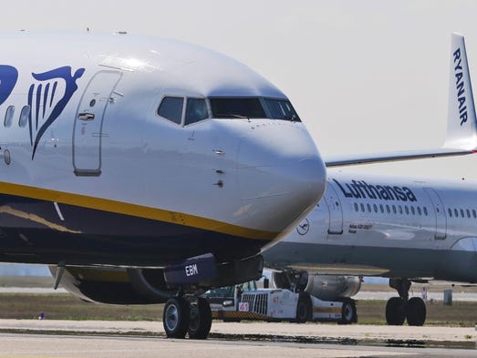 A Ryanair plane passes a Lufthansa aircraft at the