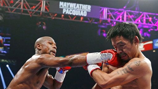 Floyd Mayweather Jr., left, connects with a right to the head of Manny Pacquiao, from the Philippines, during their welterweight title fight on Saturday, May 2, 2015 in Las Vegas. (AP Photo/John Locher)
