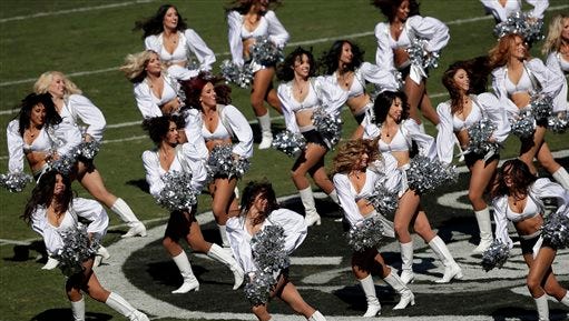 FILE - In this Oct. 29, 2014, file phot, Oakland Raiders cheerleaders perform before an NFL football game between the Raiders and the Arizona Cardinals in Oakland, Calif. California lawmakers are sending Gov. Jerry Brown a bill making it clear that professional cheerleaders are sports team employees. The bill approved by the state Senate on Monday, June 29, 2015, would require that cheerleaders be paid at least minimum wage if they work for professional sports teams based in California. AB202 says they would have to be paid for overtime and sick leave, the same as other employees. (AP Photo/Marcio Jose Sanchez, File)